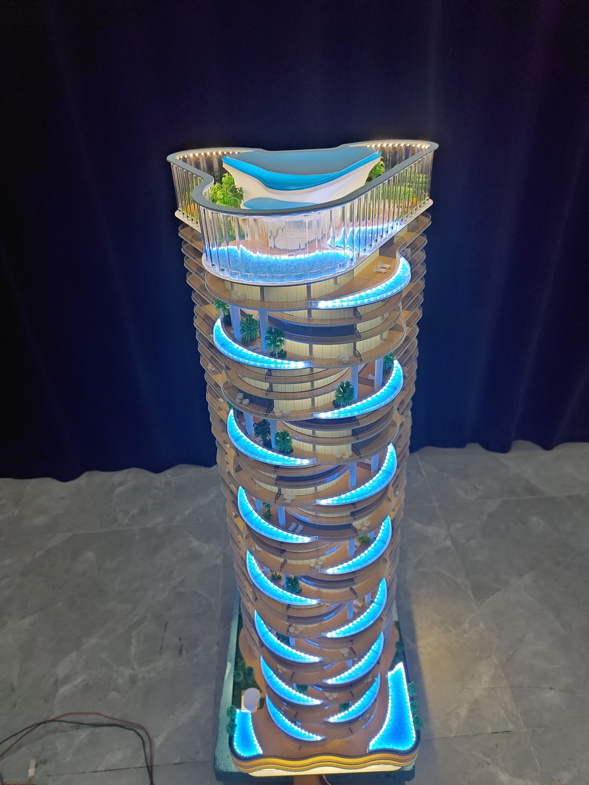 Illuminated residential tower scale model with rooftop pool